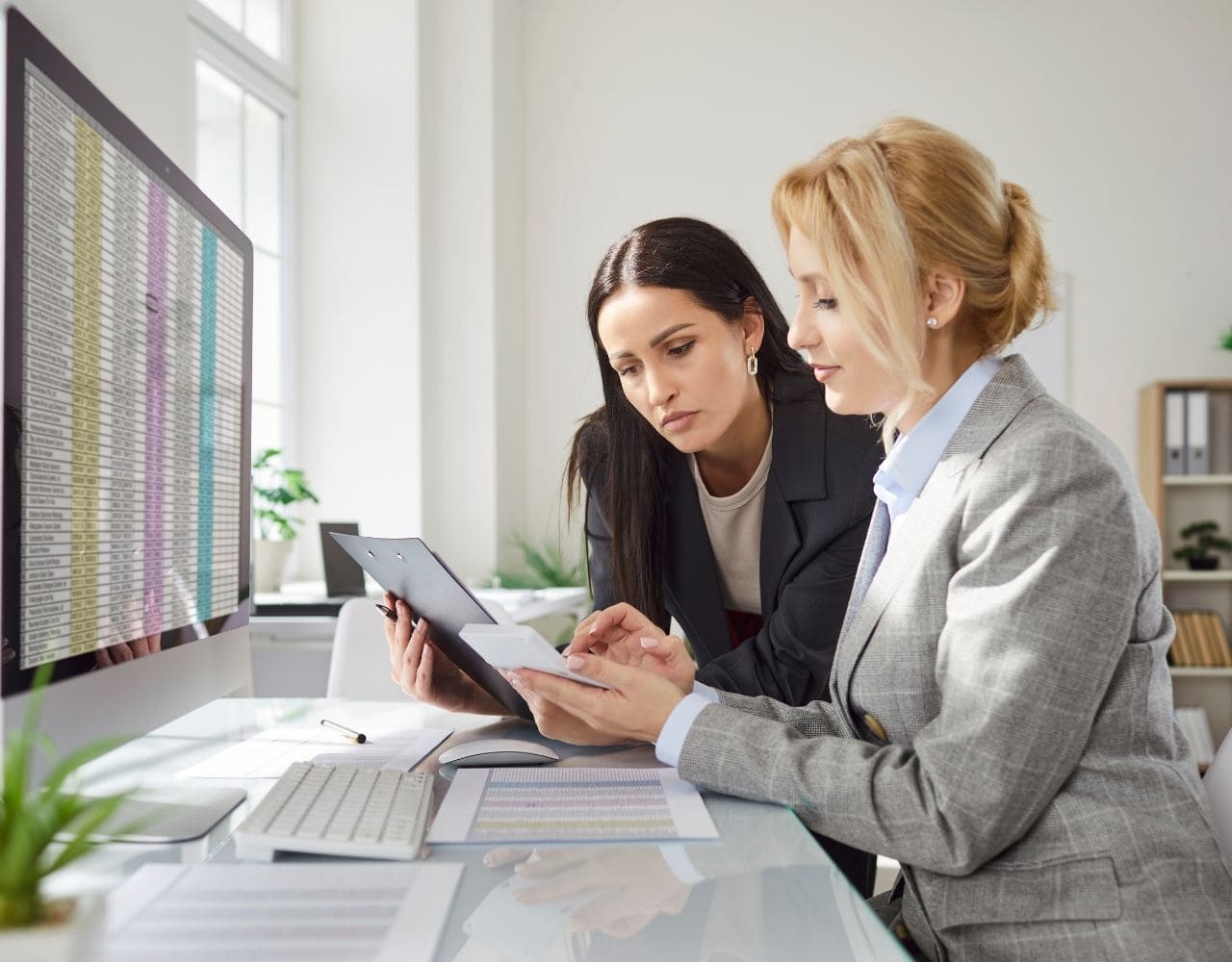 Liasse fiscale en ligne : deux femmes salariées utilisent Teledec sur leur ordinateur de bureau pour réaliser une liasse fiscale de manière automatique et conforme.